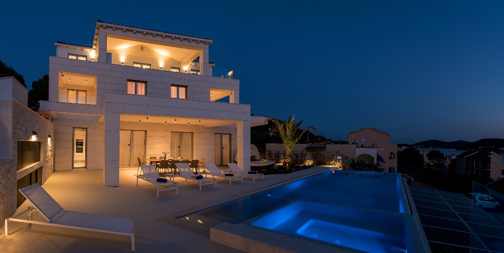 Villa bei Nacht mit beleuchteten Pool